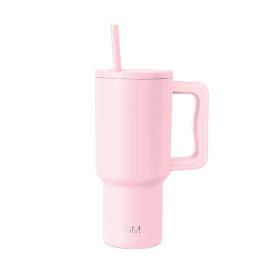Pale pink insulated tumbler with handle on white background